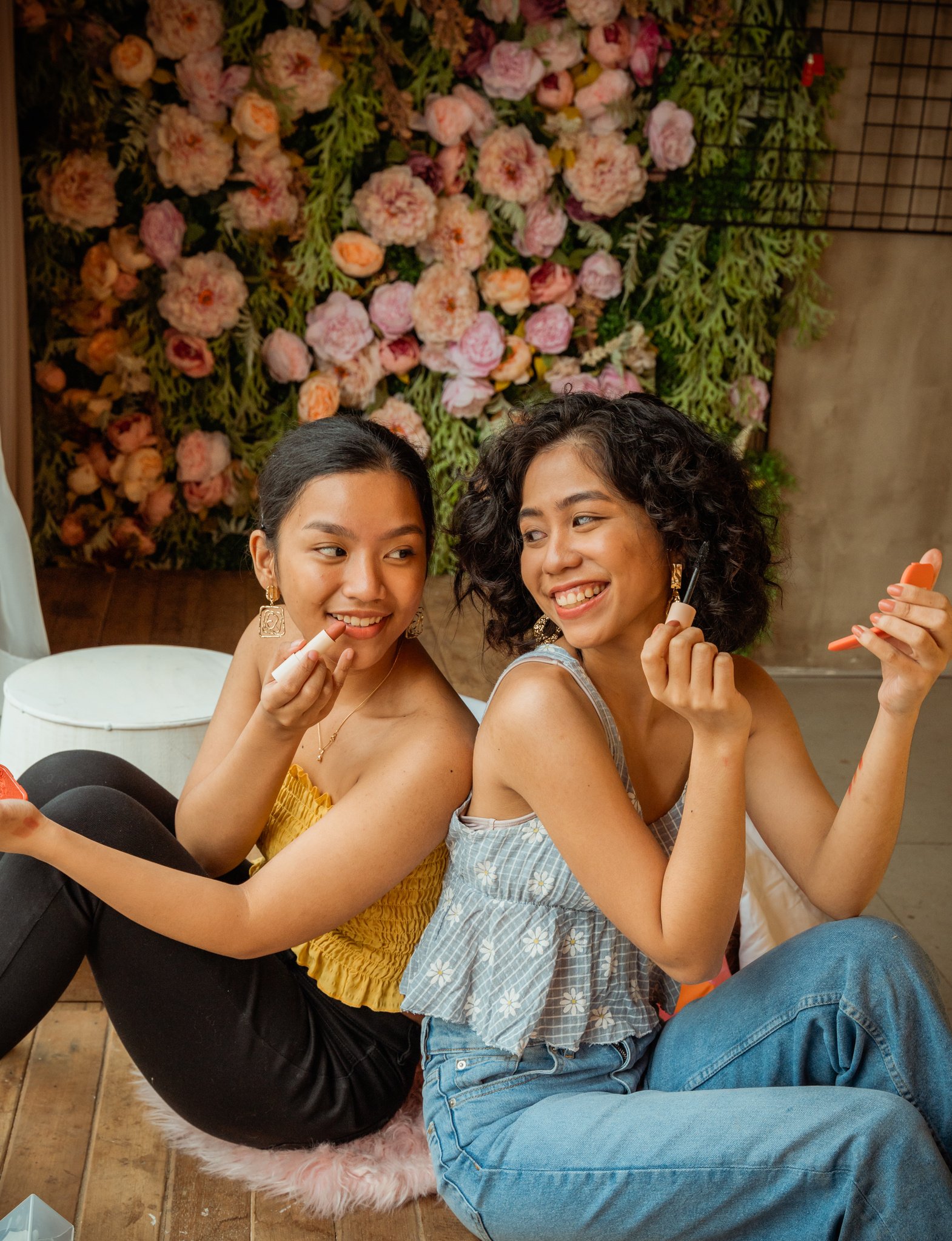 Smiling Women Applying Lipstick and Mascara on Face